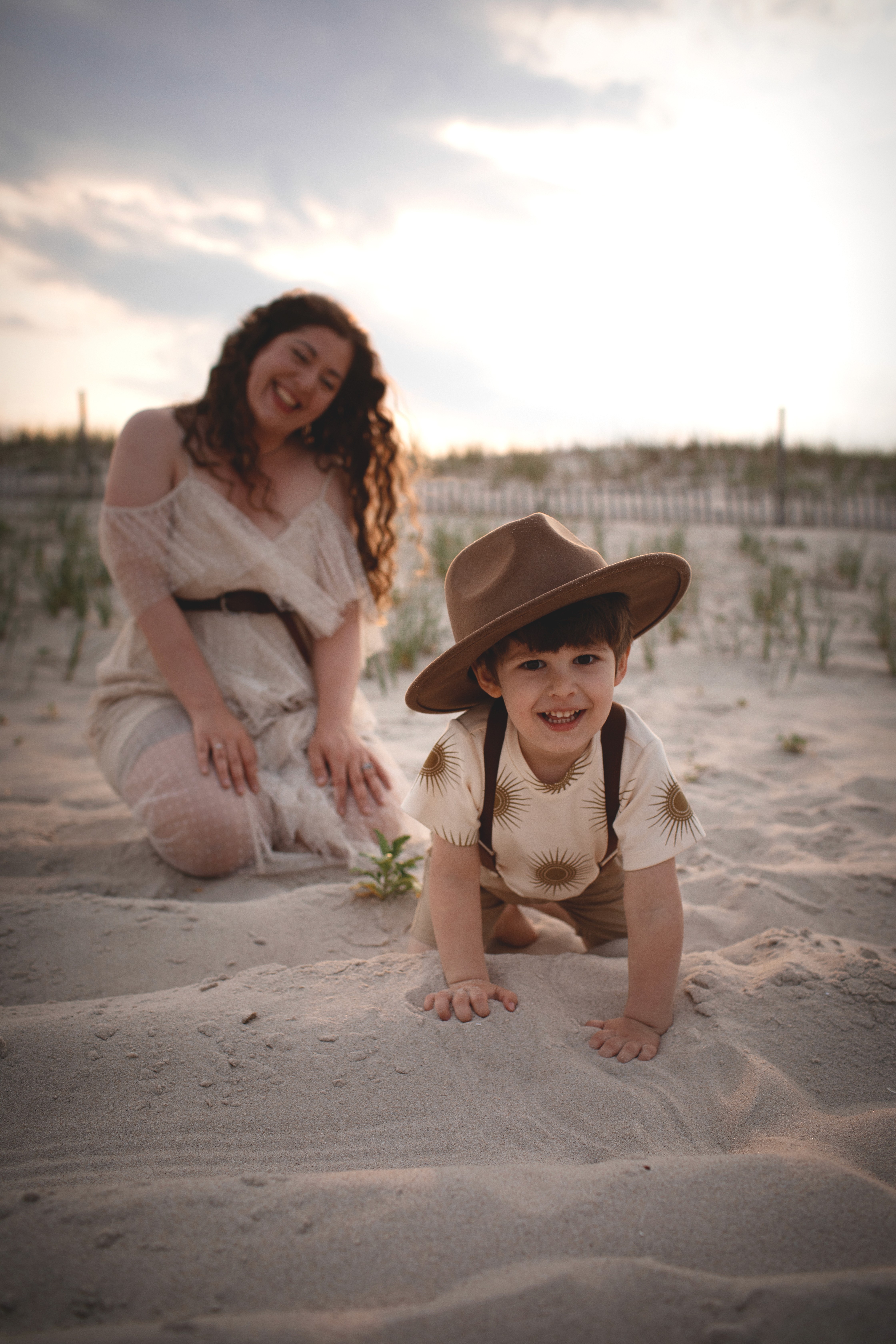 Mother and child playing in the sand during a candid family moment at the beach