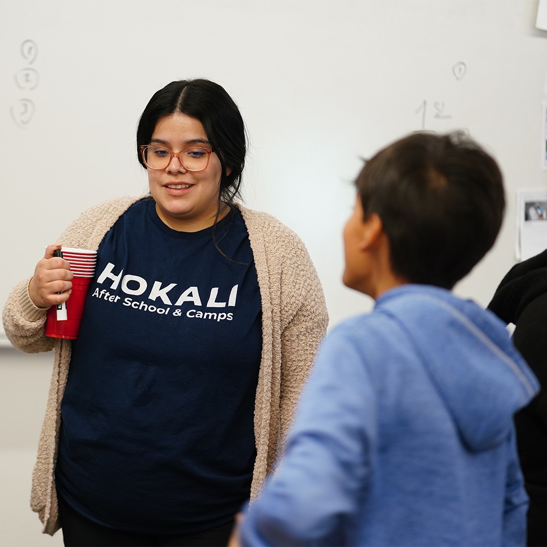 HOKALI educator providing classroom assistance during instructional time.