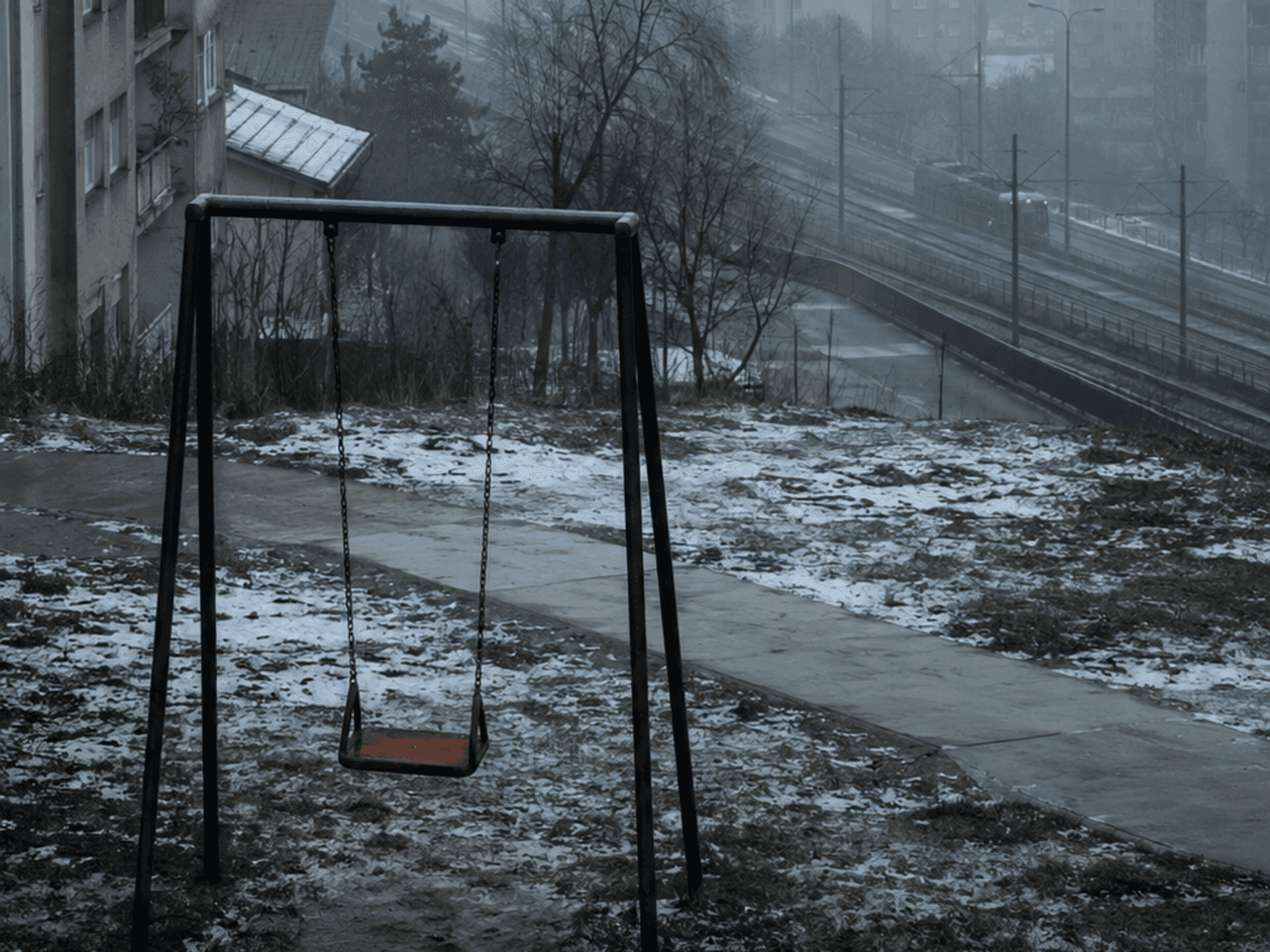 Child on a swing in Sarajevo winter smog