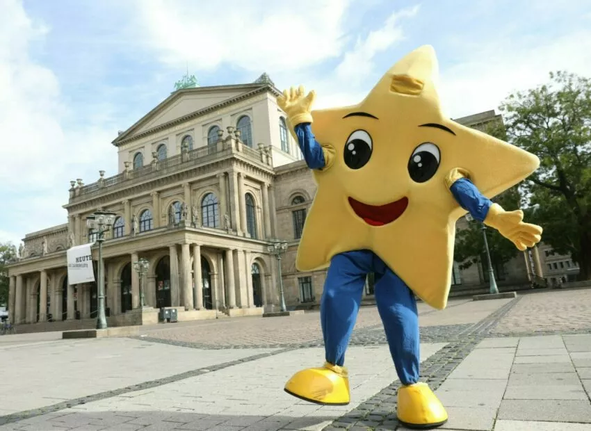 Fröhlicher Stern-Maskottchen vor dem Opernhaus in Hannover.