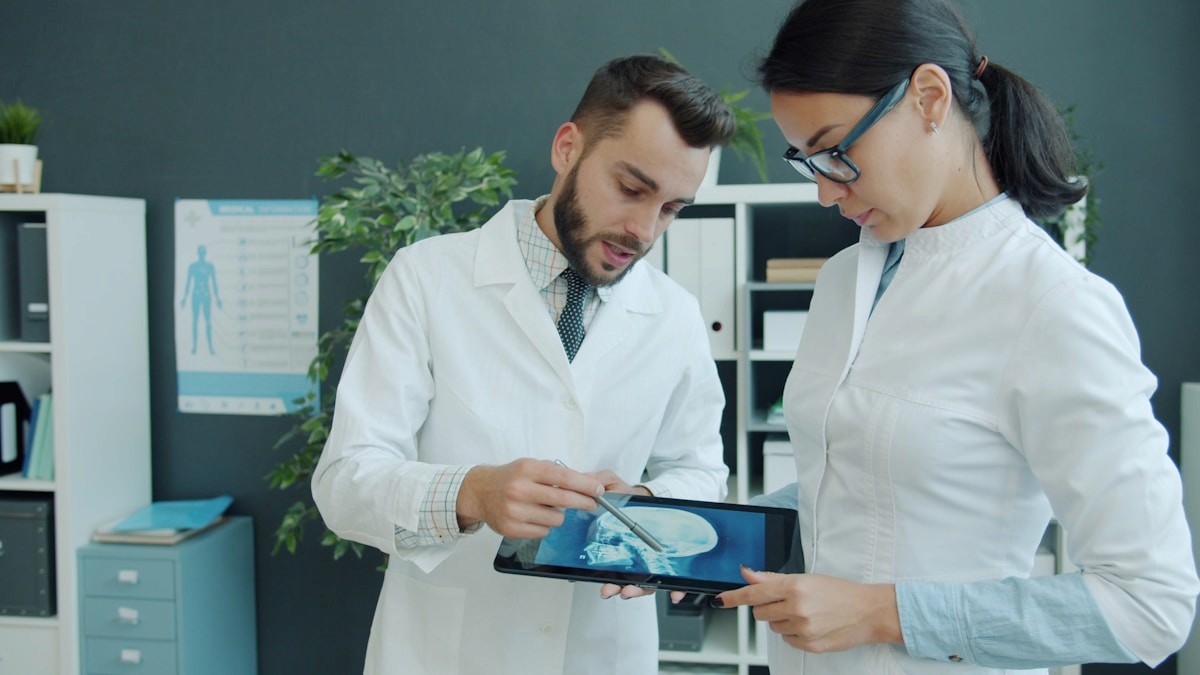 Healthcare professionals reviewing a medical scan on a tablet.