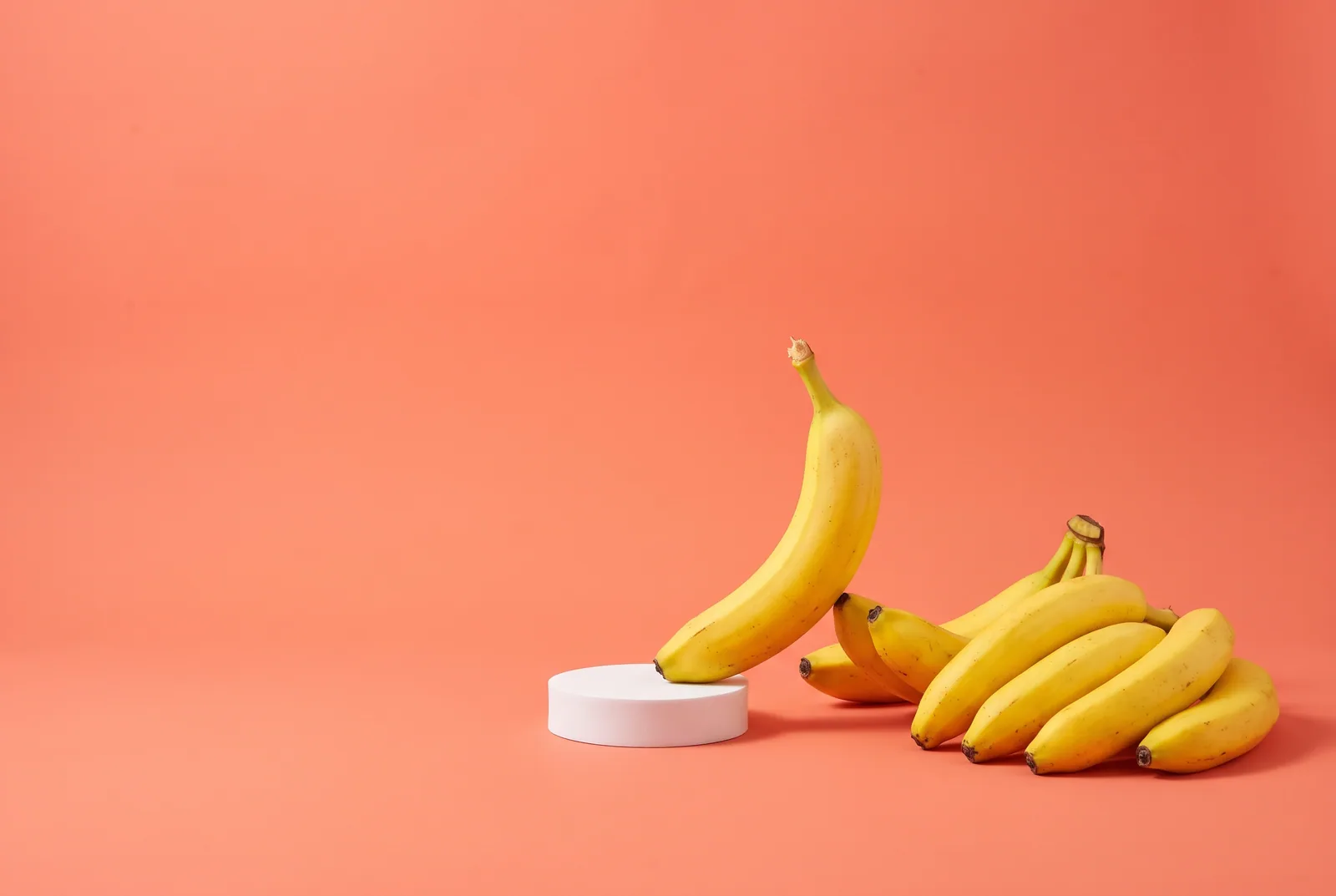 A banana stepping out of a crowd onto a small white podium, switching from NoFap to QUITTR