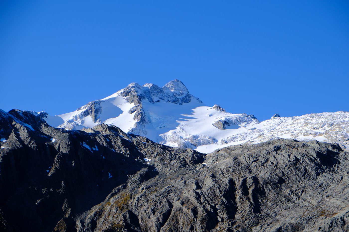 A snow-capped peak against a clear blue sky