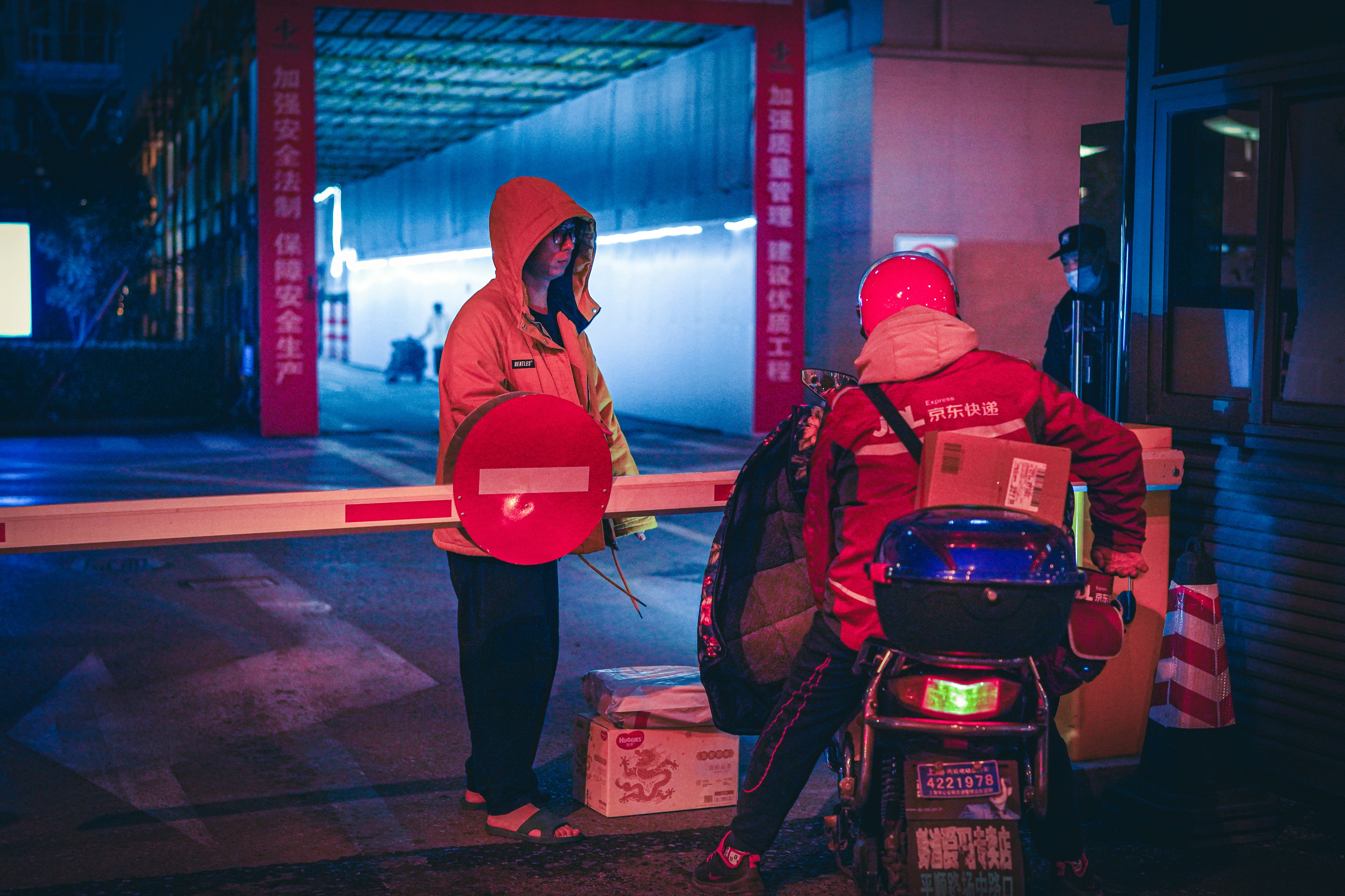 a couple of people standing next to a motorcycle