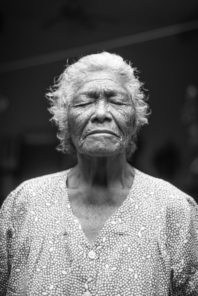 black white image showing an older female with closed eyes.