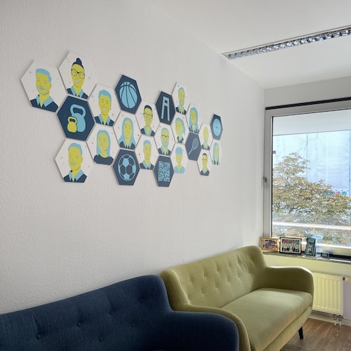 Ein Blick in unserer Wartezimmer. An der Wand sind die Bilder unserer Mitarbieter im Comic Stil.