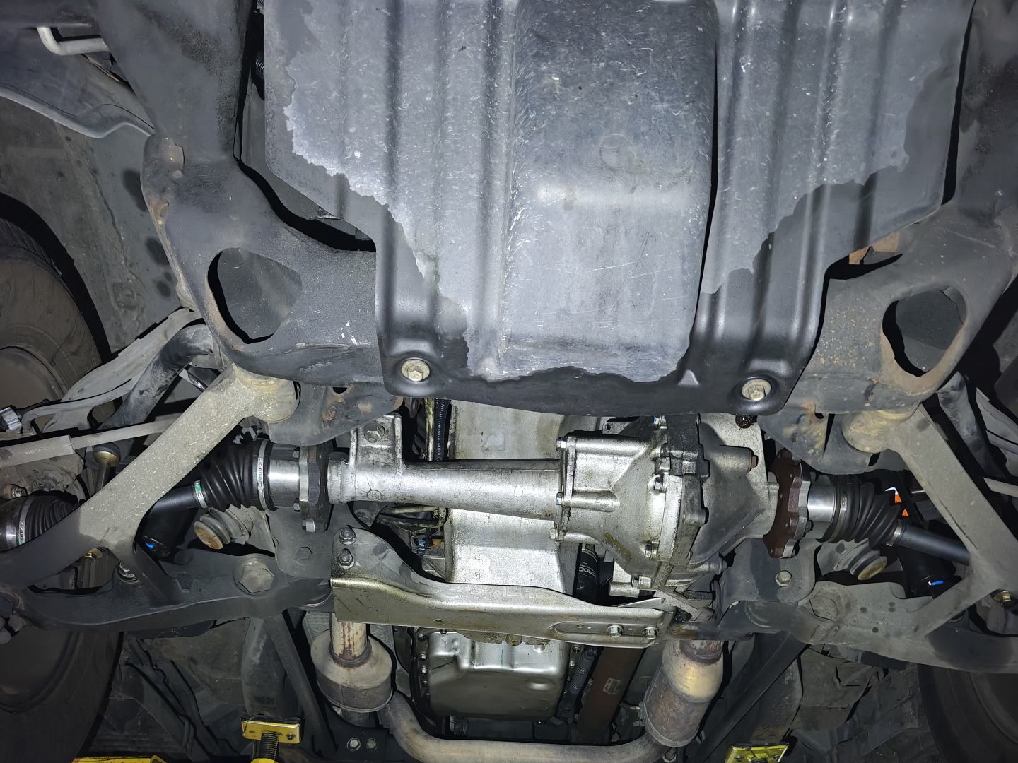 Underside of the 2004 Cadillac Escalade ESV on the lift, showing the front differential, axles and skid plate