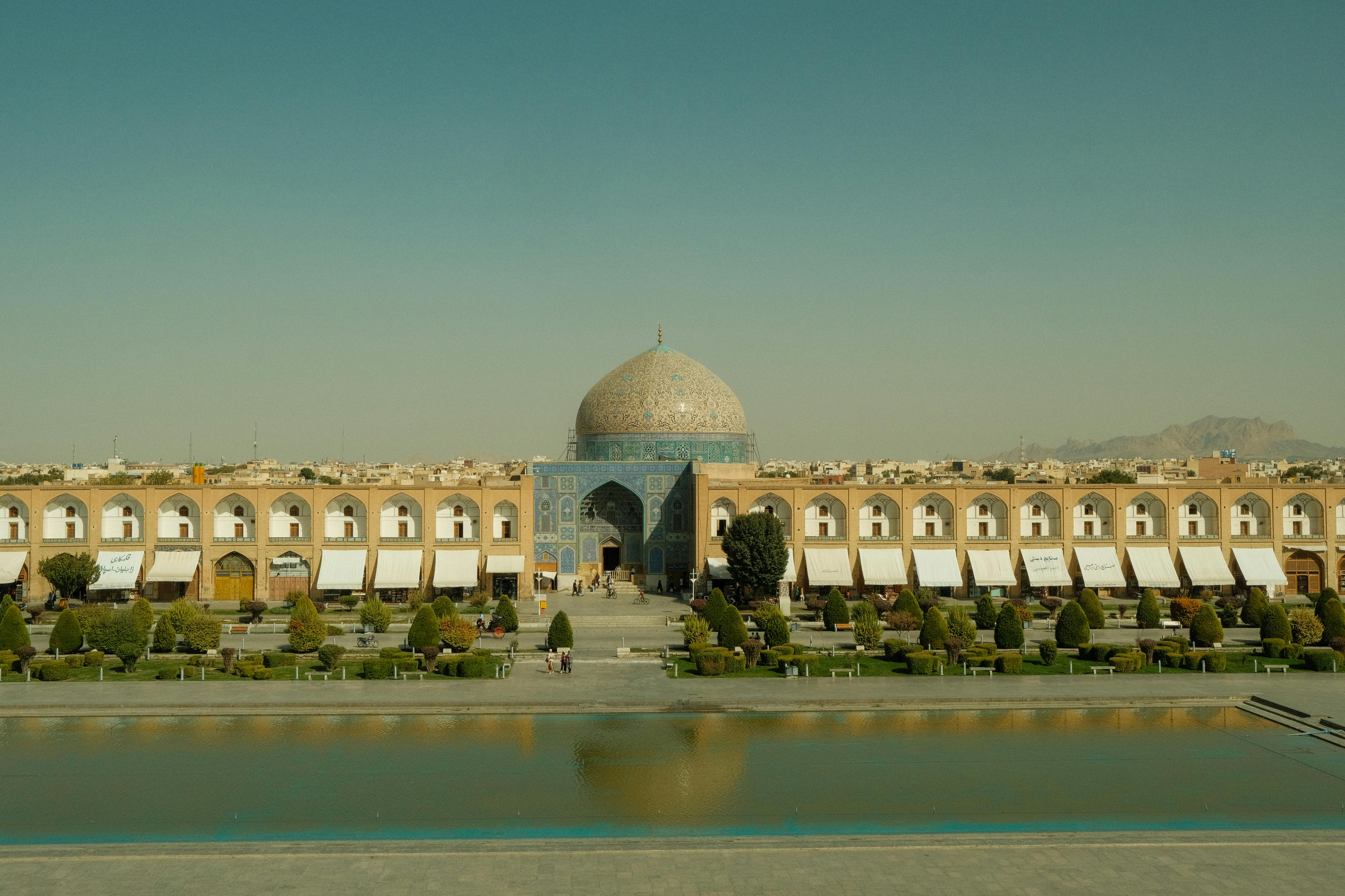 red train travelling near body of water