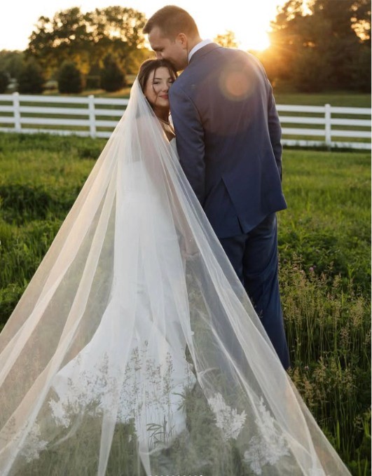 woman in white floral dress holding white flower