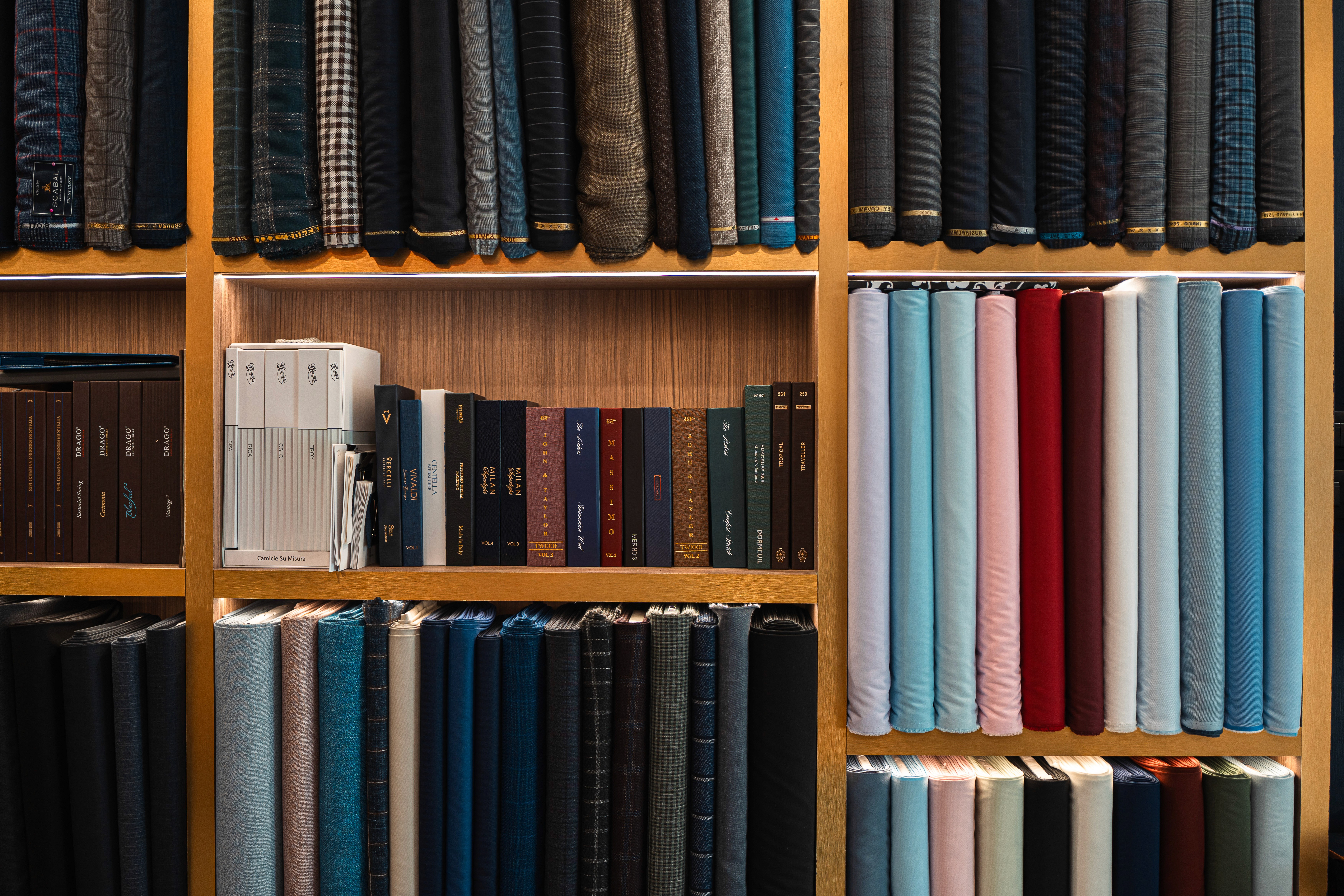 Two men preparing to put on a suit jacket.
