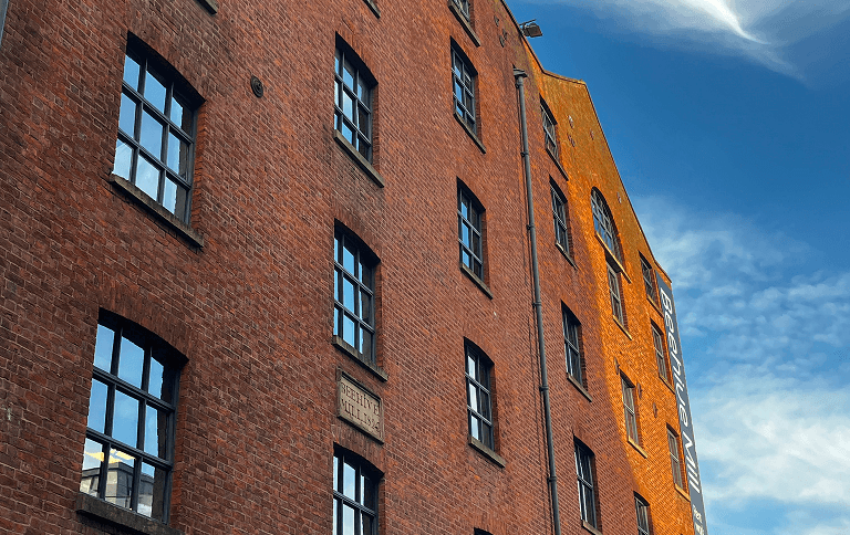 An image of a red bricked building wit ha blue sky