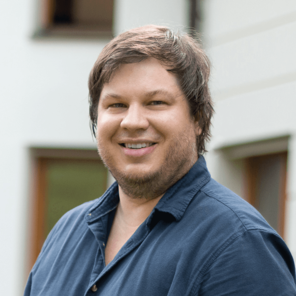 Das Bild zeigt einen jungen Mann der in die Kamera grinst