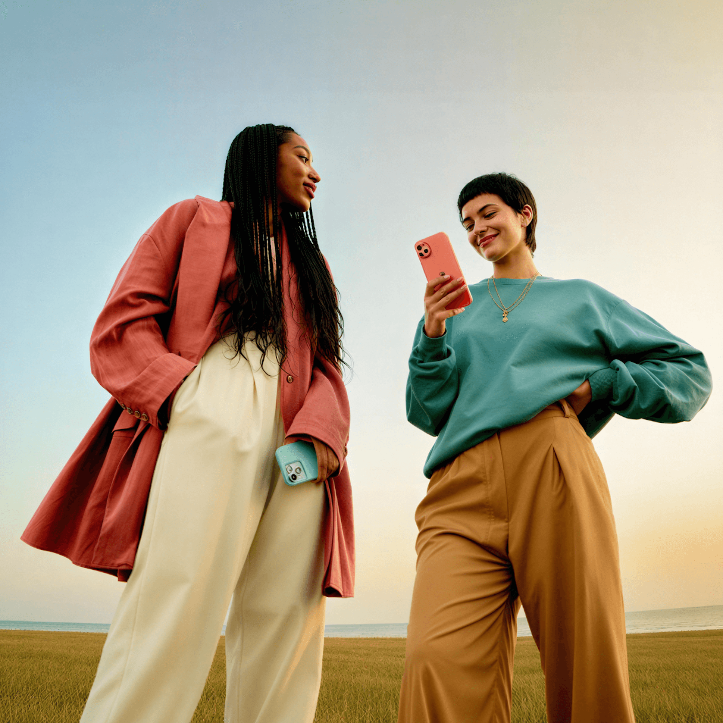 Two travelers checking a phone in a golden field