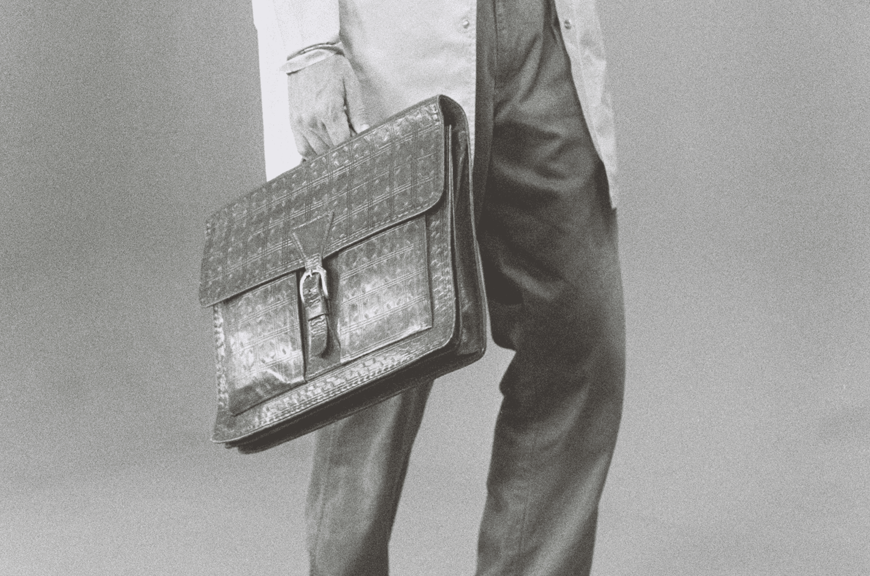 Elegant businessman in suit and gloves holding a textured leather briefcase, symbolizing professional LinkedIn automation tools for B2B lead generation
