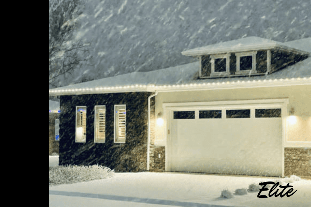 Heavy snow covering a home and garage, highlighting winter risks and the need for secure garage door protection.