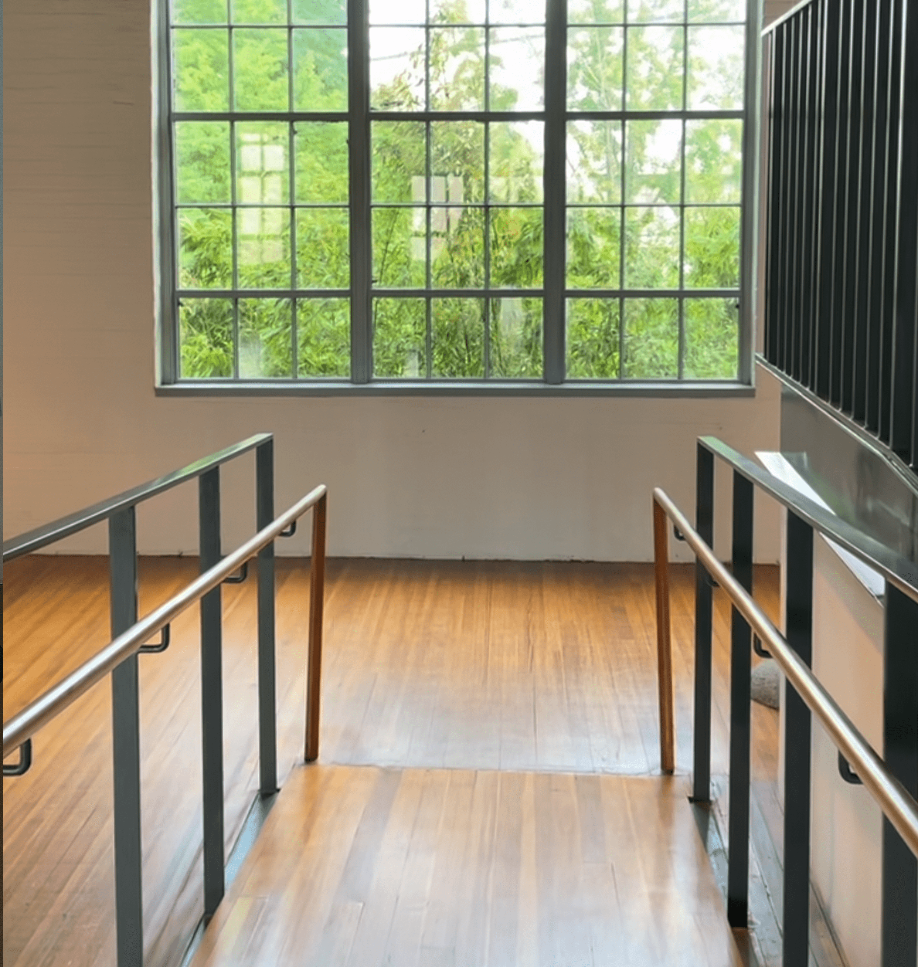 Staircase with metal railings and bamboo garden view through industrial windows, The Noguchi Museum New York