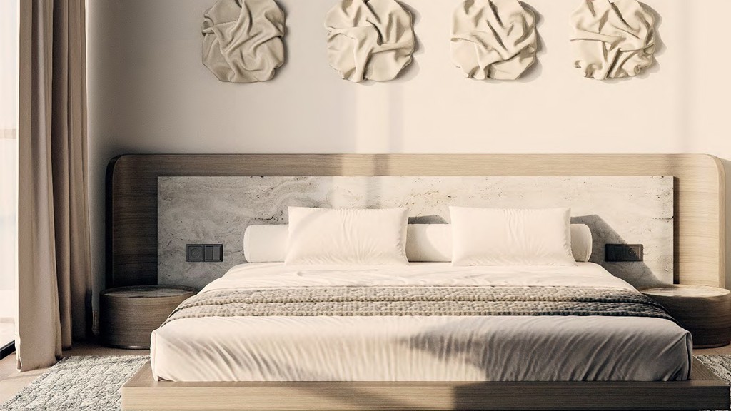 Contemporary bedroom in Edgewater Residences with a white bed and stylish brown pillows.
