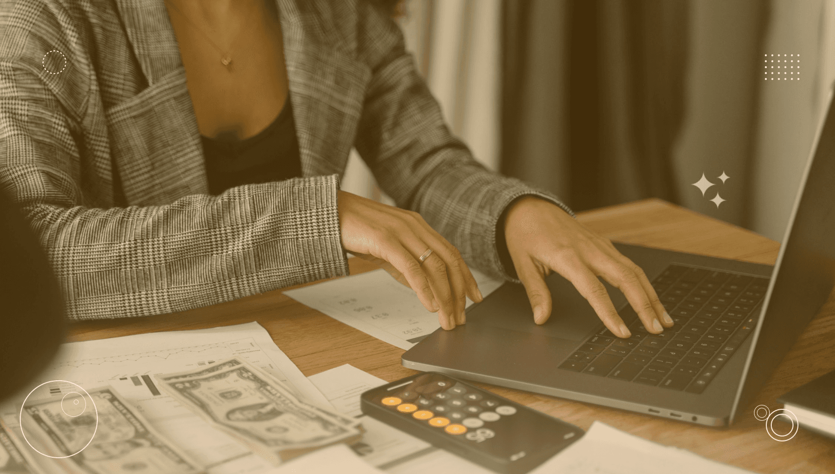 A woman working in a laptop with some money in her desk.