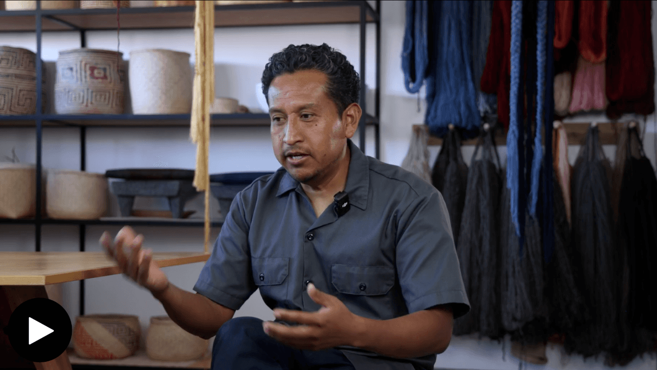 Porfirio Giutierrez in his studio, with ceramics and yarn behind him.