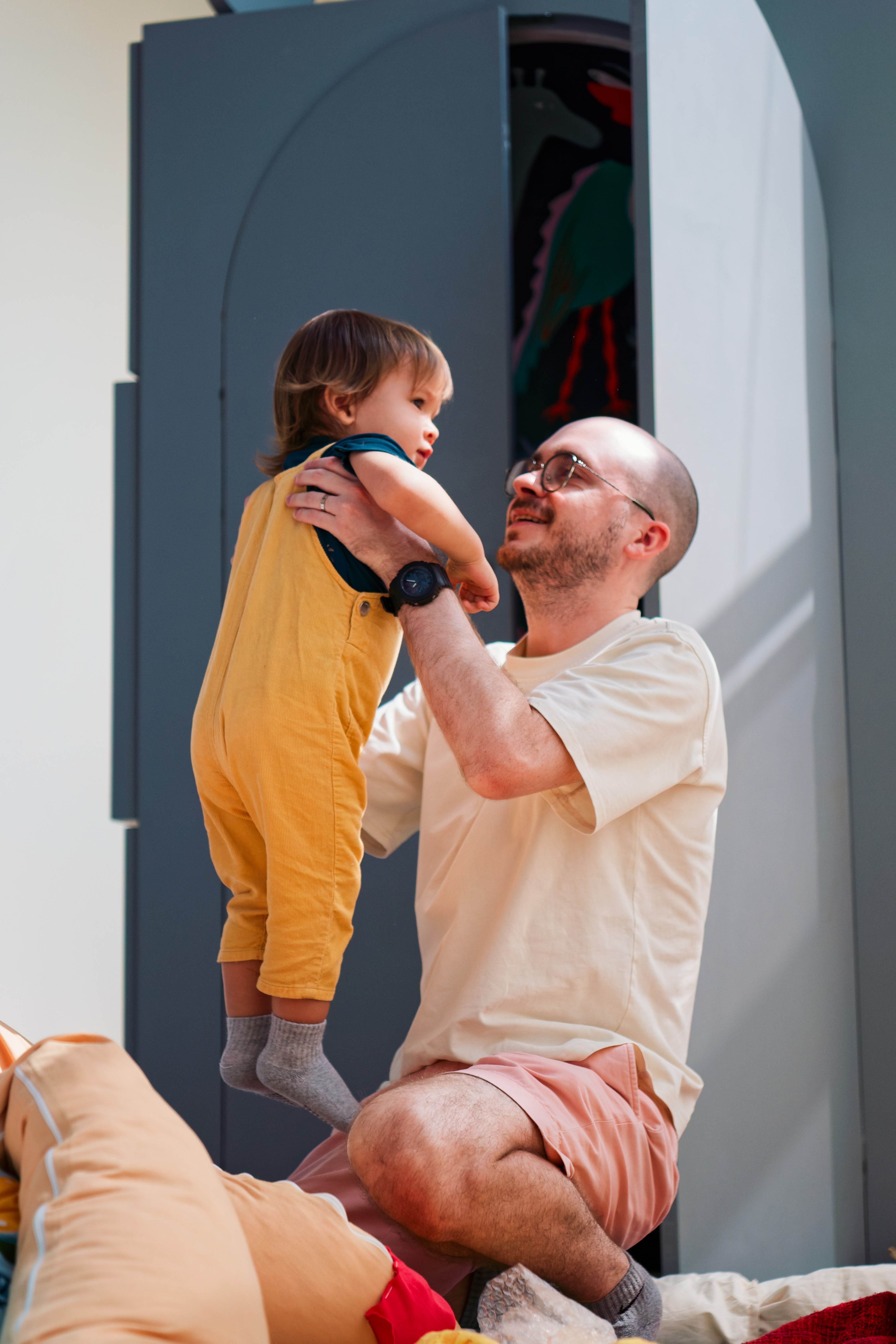 a father holding a child up in the air and smiling at him