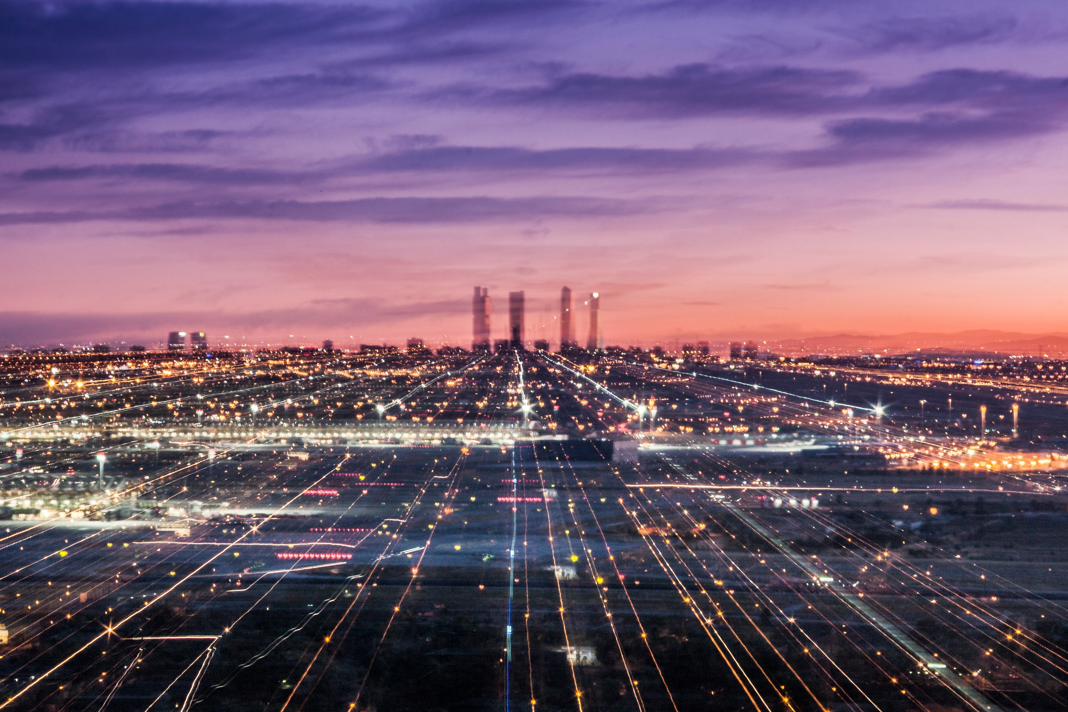Contact page hero featuring a high-angle photo of Madrid’s cityscape at sunset, with city lights glowing and the title 'Contact' in large white letters in the bottom left corner.