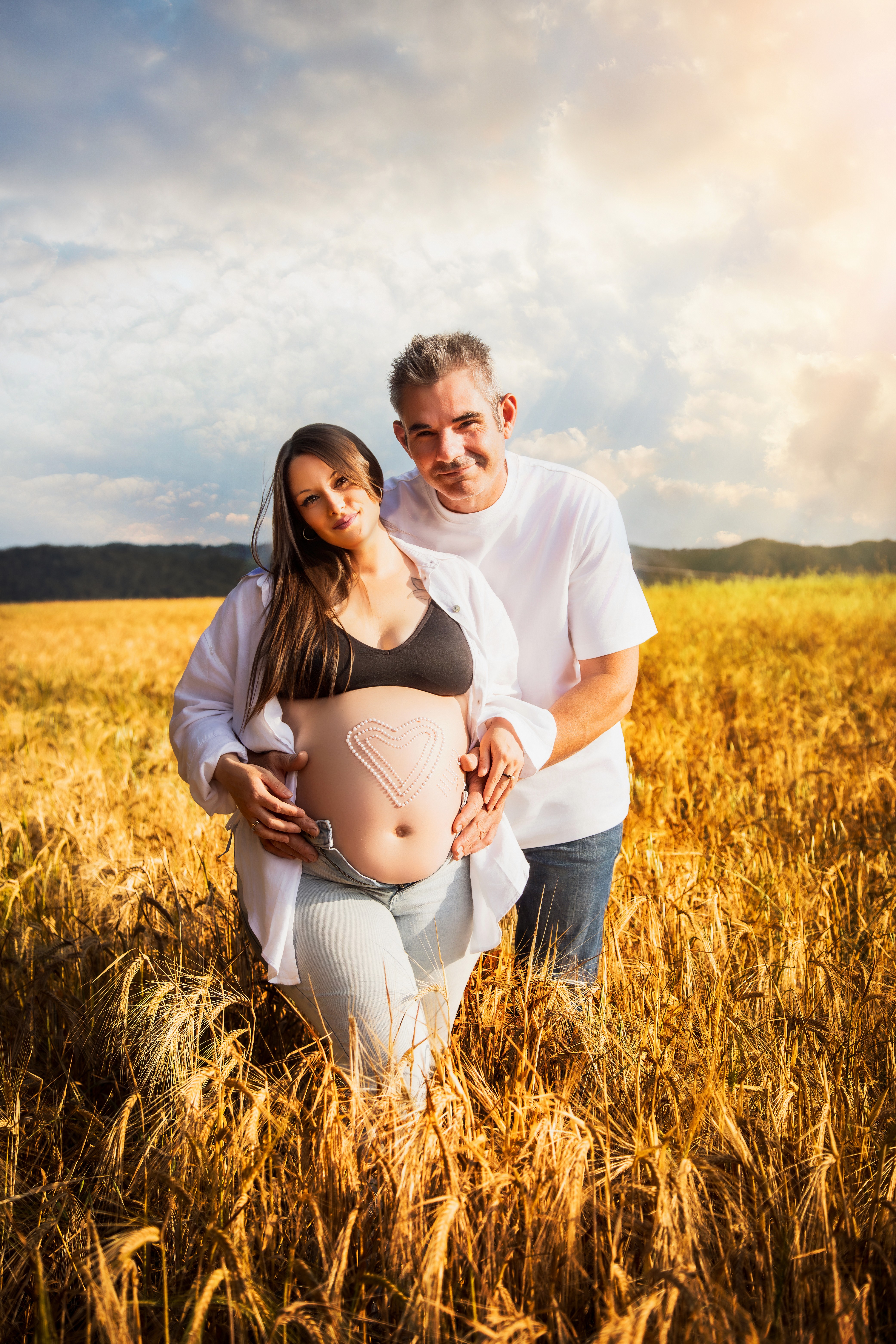 Premamá y pareja en un campo de trigo