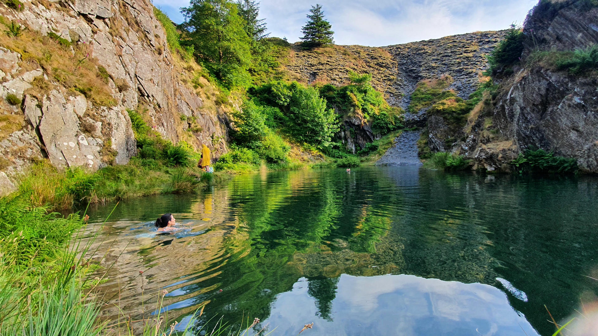 Samira standing at edge of cliff looking at clouds