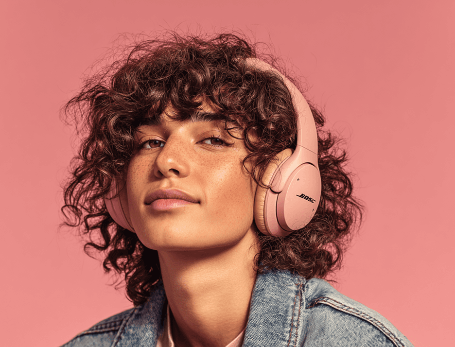 A young person listening to music with headphones on, looking at the camera