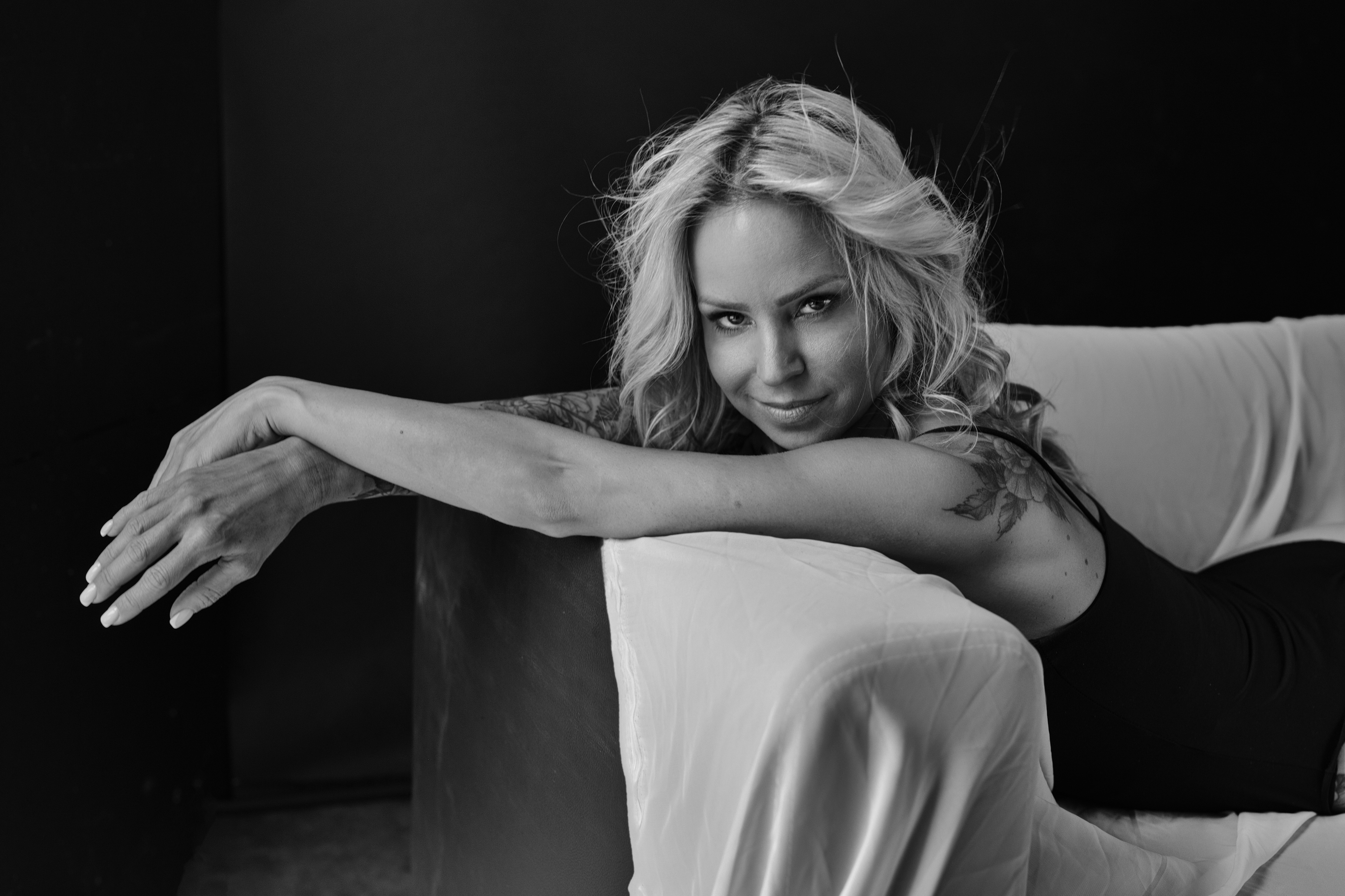 Agnieszka Czyzkowska kobiece sesje fotograficzne Warszawa kobieta lezaca na kanapie z tatuazem czarno-biale