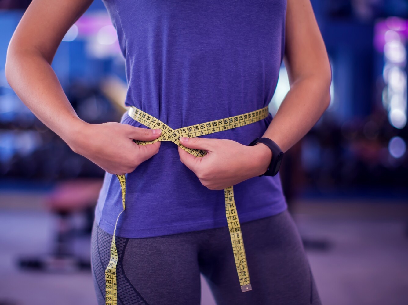 woman checking her weight loss results with a measuring tape after learning how to lose weight without working out