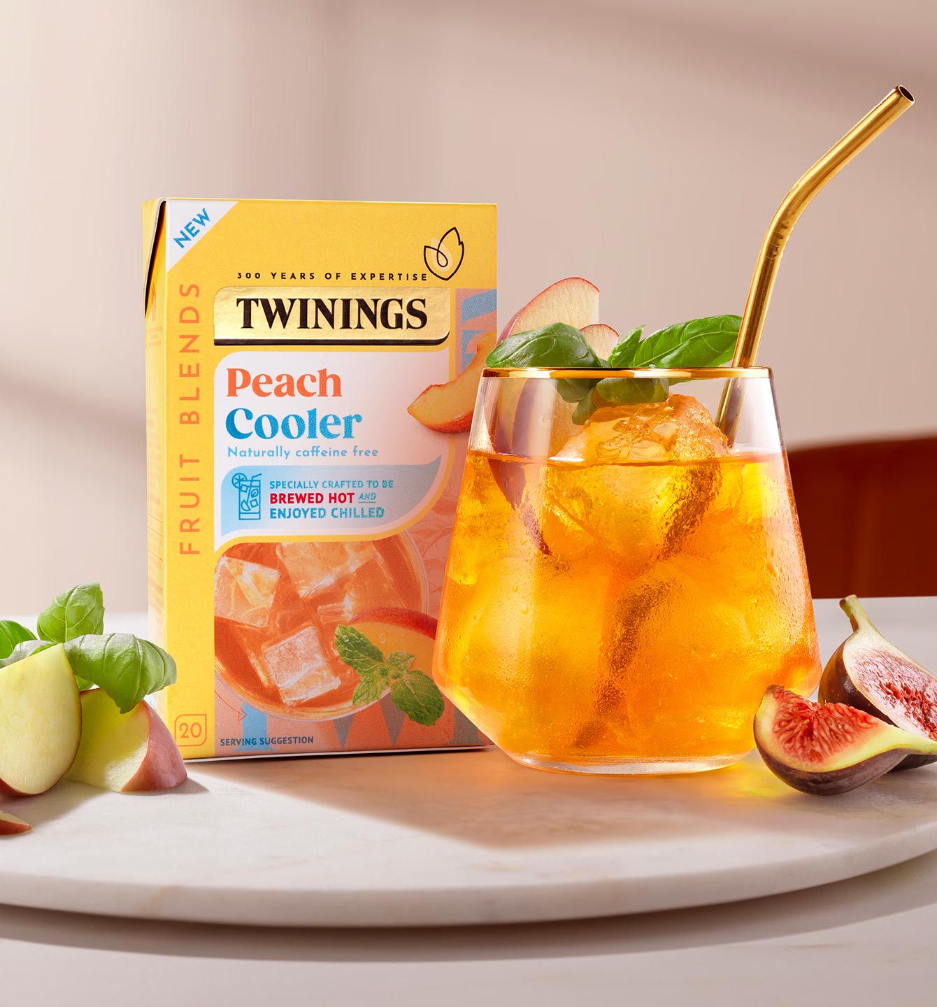 Box of Twinings Peach Cooler Tea next to a glass with ice and tea in it.