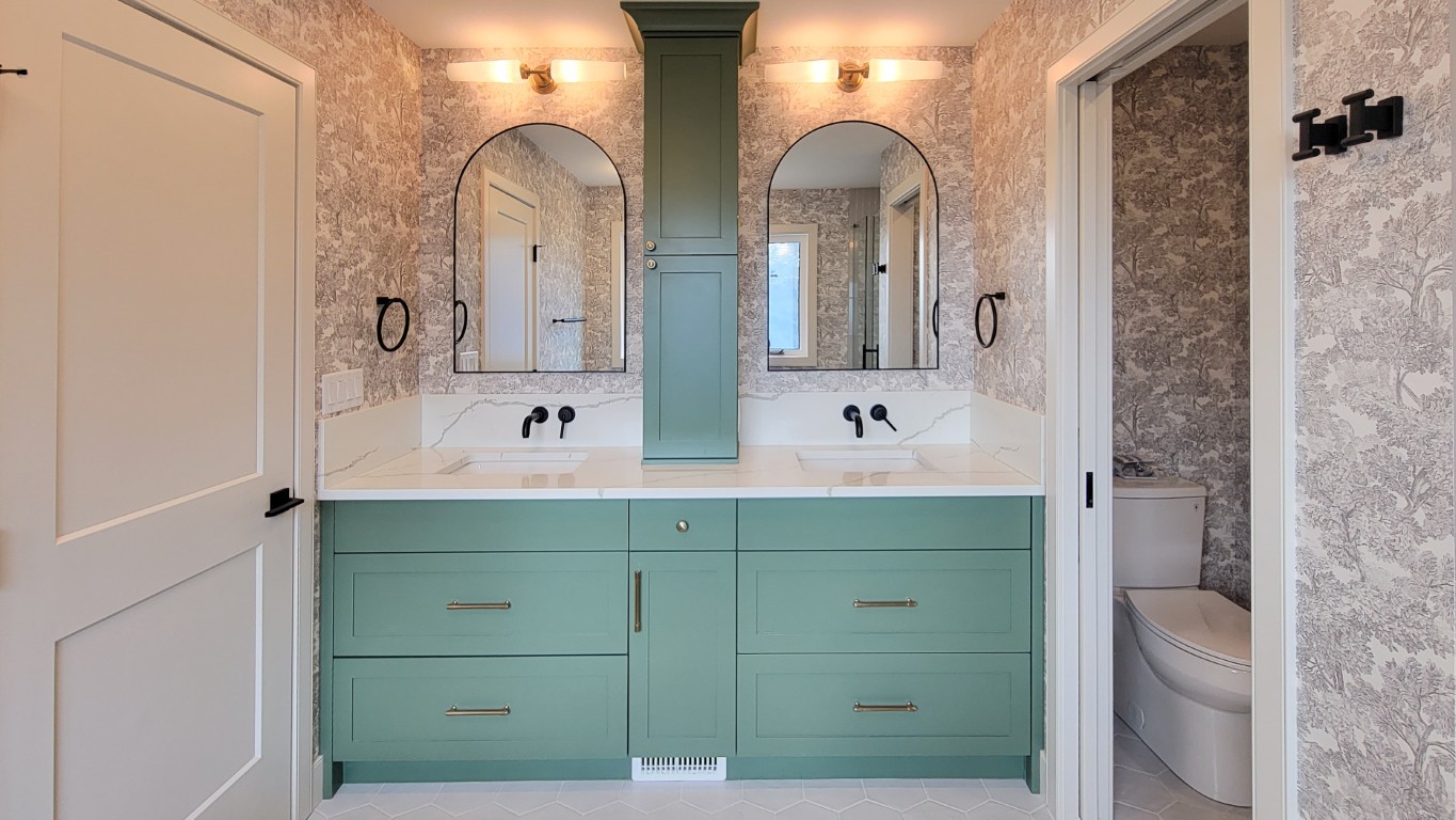 Image of Luxury bathroom interior with green cabinets, double sink, mirrors, and marble countertop by KHD Homes.