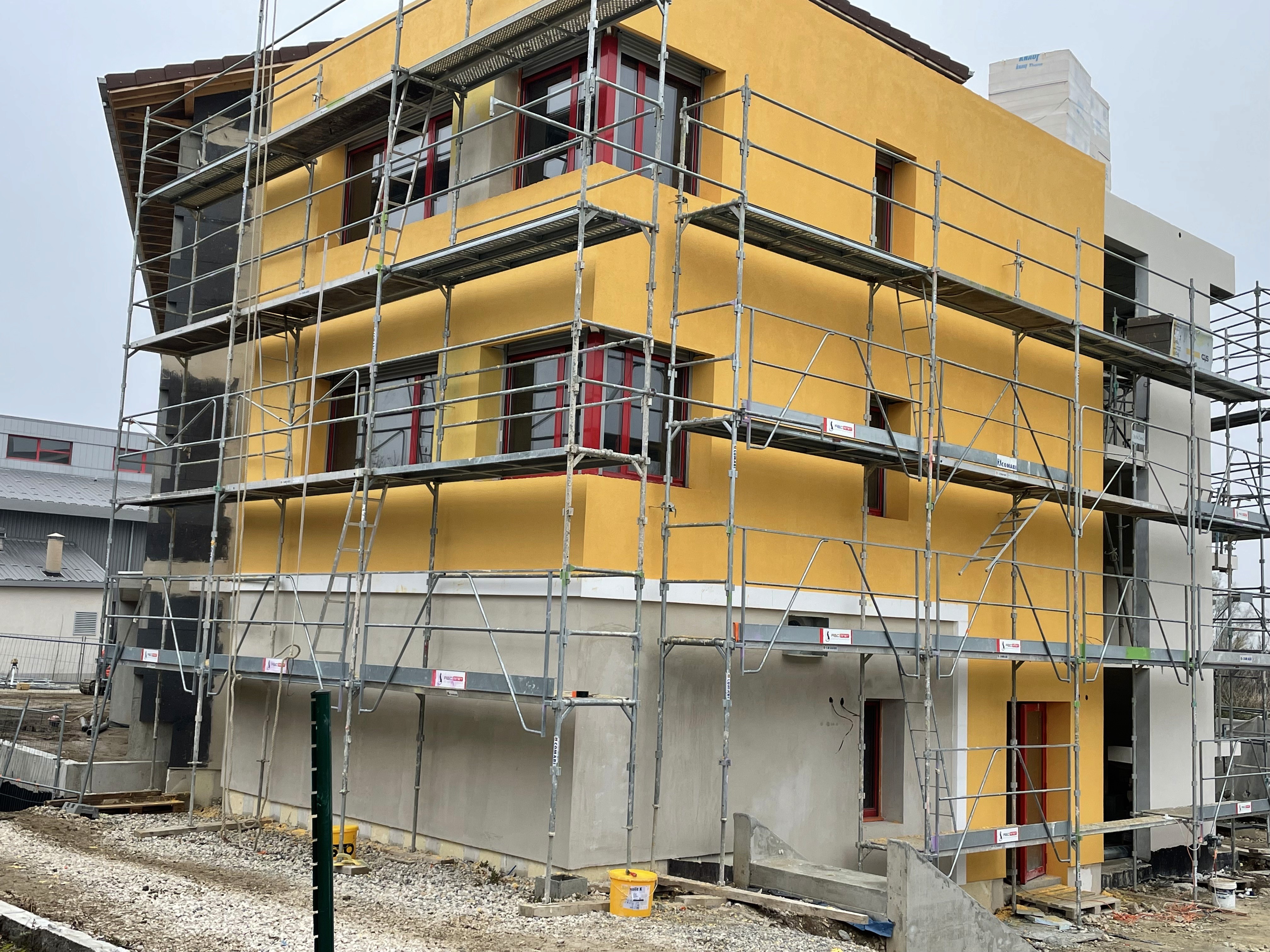 Application d’un enduit coloré lors d’un ravalement de façade à Annecy