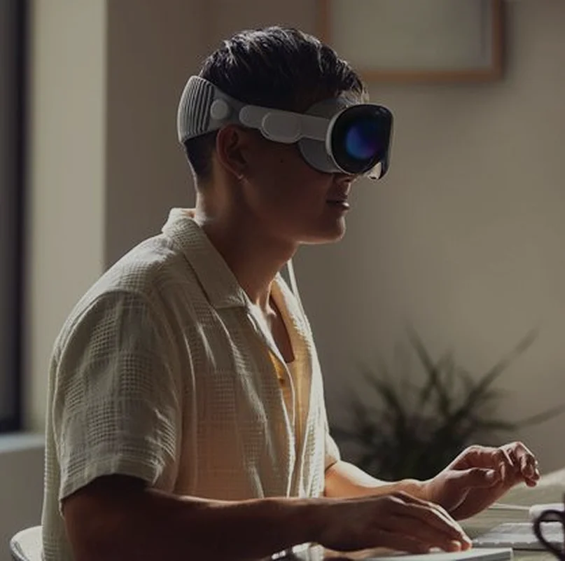User wearing Apple Vision Pro mixed reality headset spatial computing glasses for immersive AR VR experience