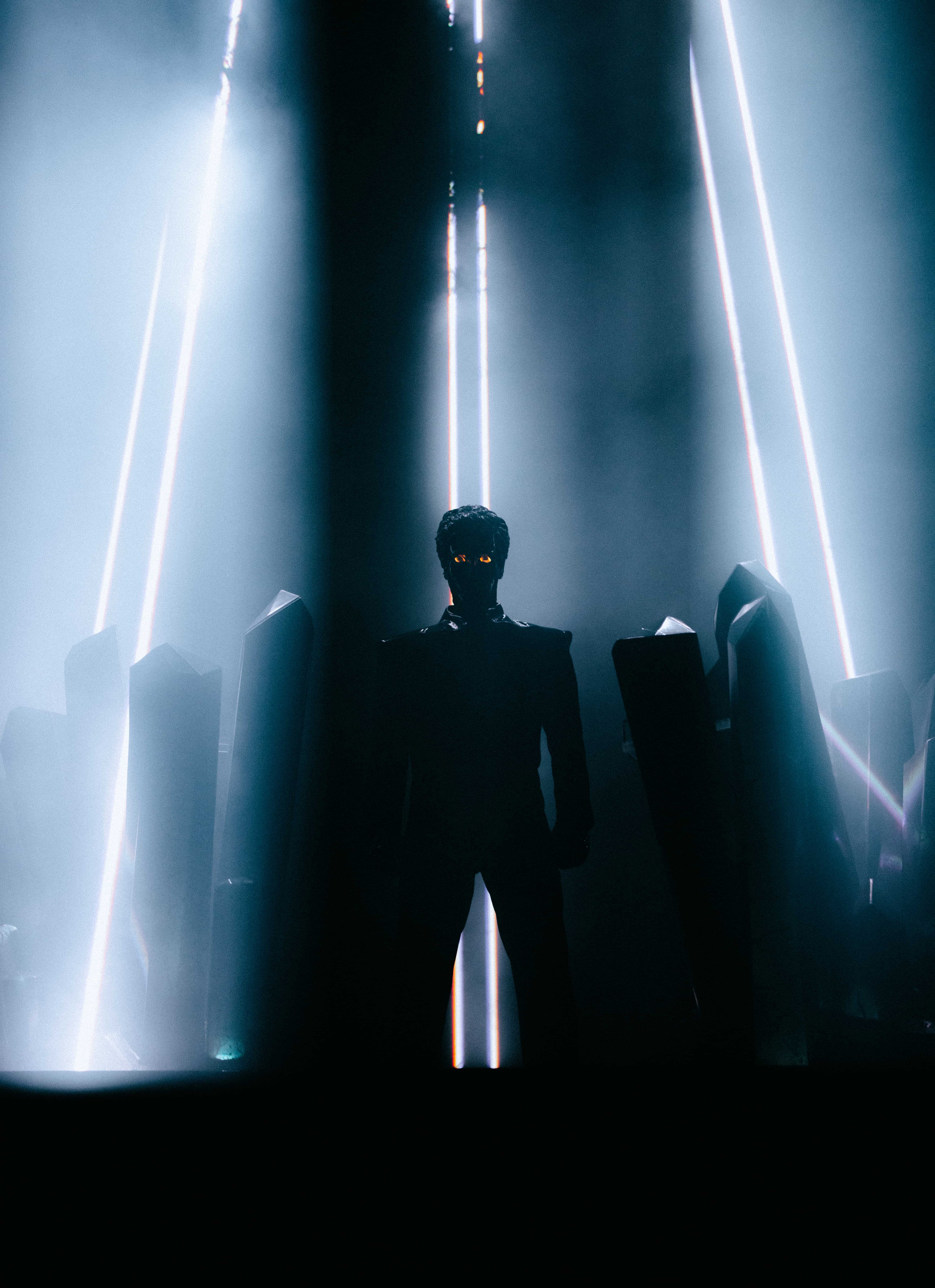 Gesaffelstein performing at Coachella 2024 in silhouette surrounded by vertical light beams and stage structures, captured by A World Away creative director Brandon Densley