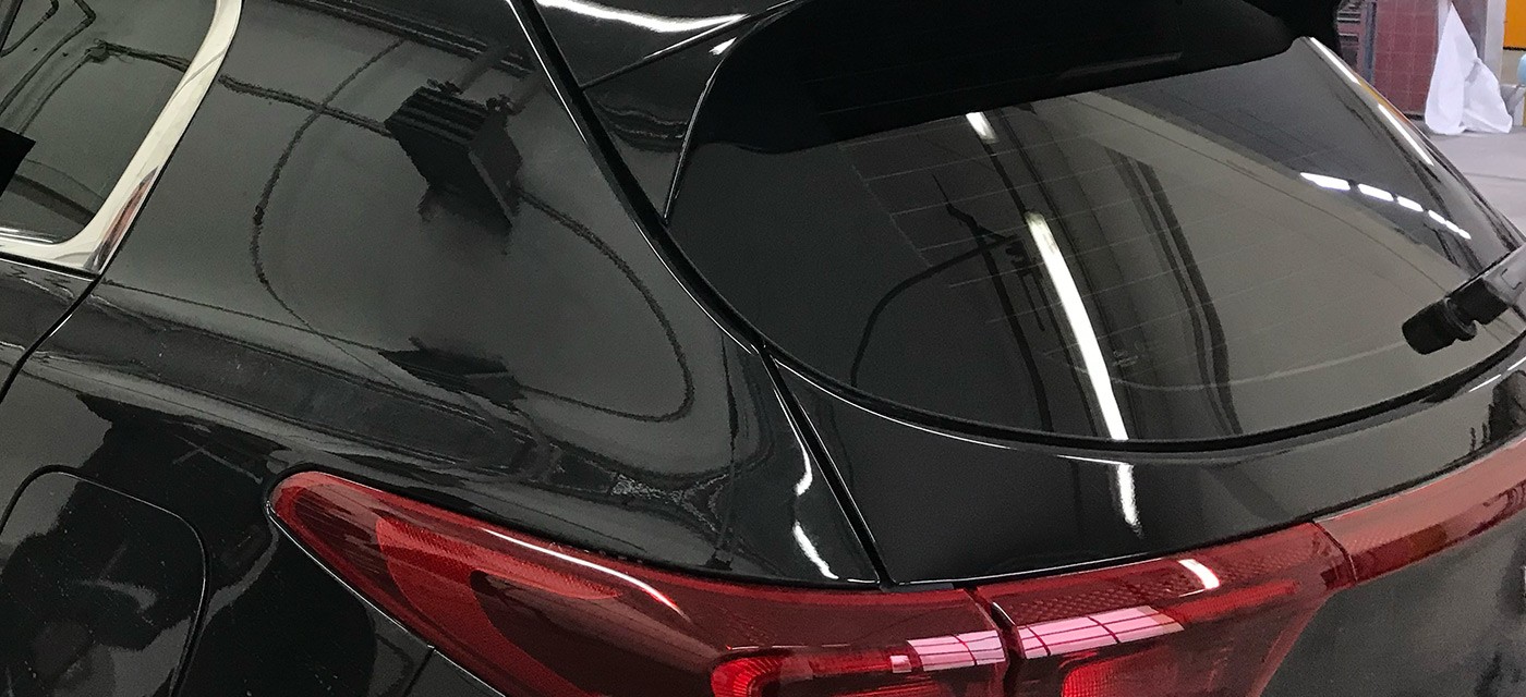 Schwarzer SUV mit dunkler Scheibentönung als Sichtschutz an den hinteren Fenstern und der Heckscheibe