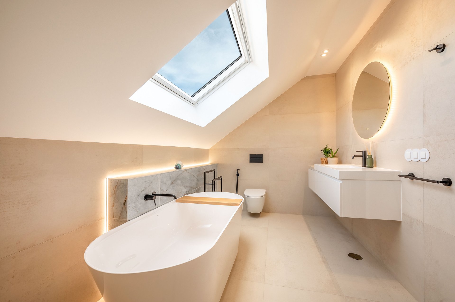 Bathroom with skylight and round mirror at Villa Flora