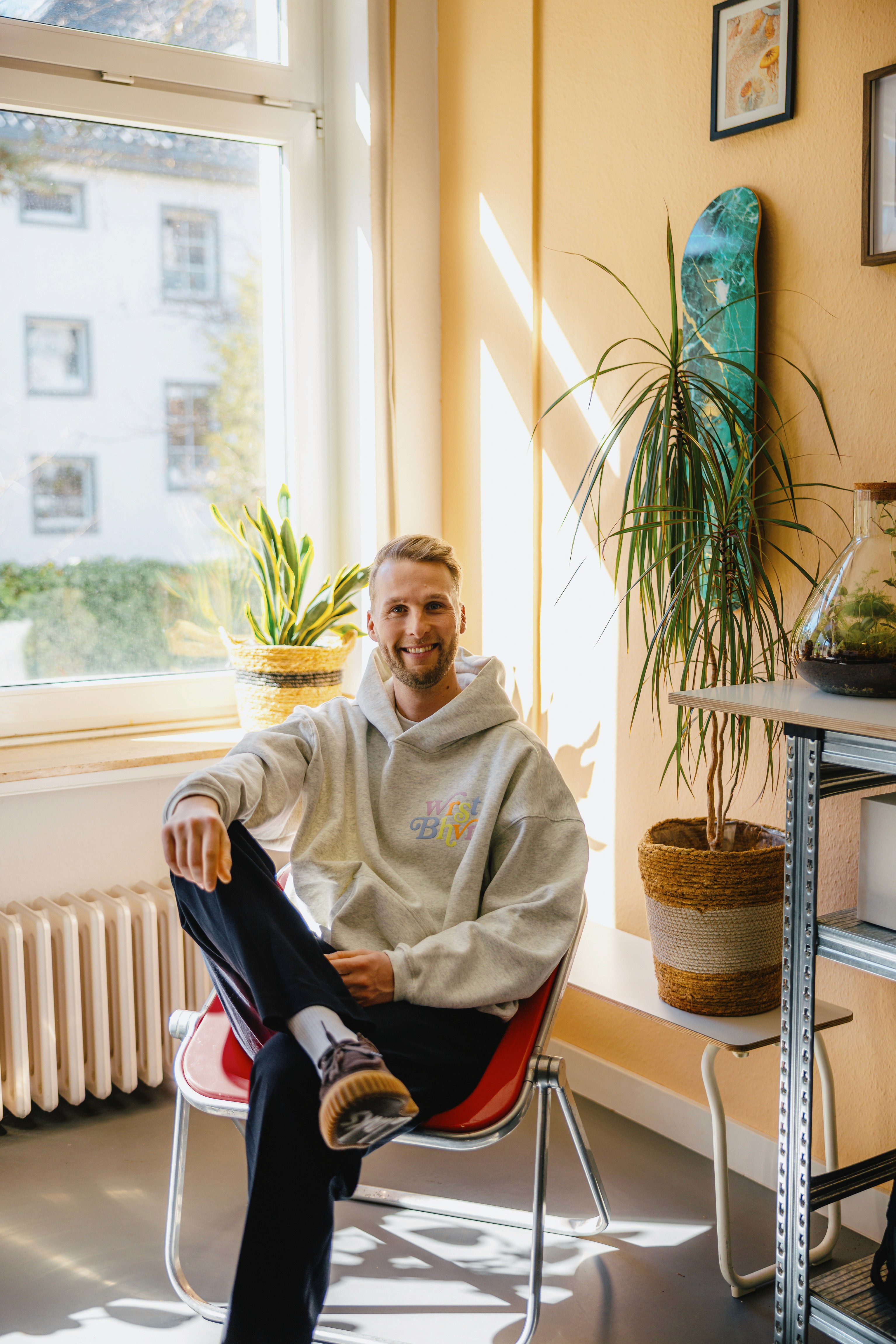 Close-up of two smiling friends with freckles, bright makeup, on a light blue background—joyful, inclusive brand portrait.