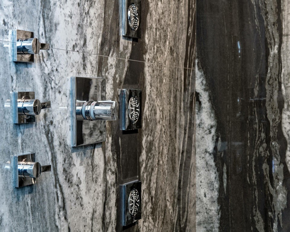 Image of Luxury bathroom fixtures mounted on marble wall, KHD Homes design-build primary ensuites with spa bathrooms.
