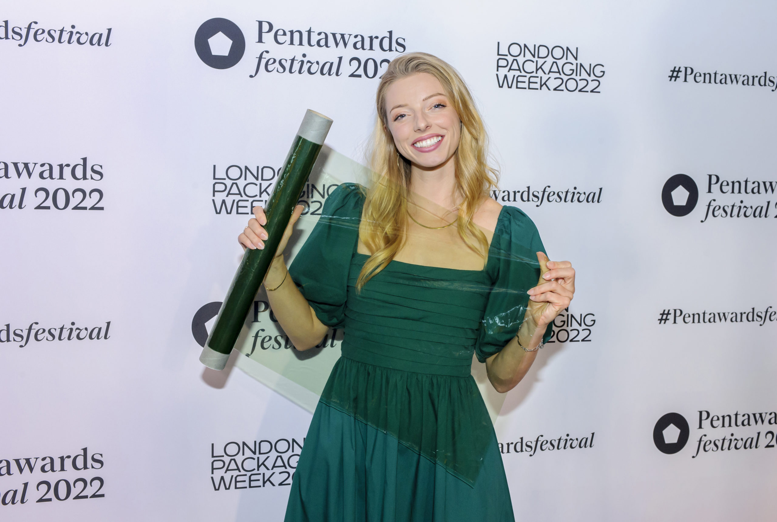 woman holding seaweed product sample in a green dress