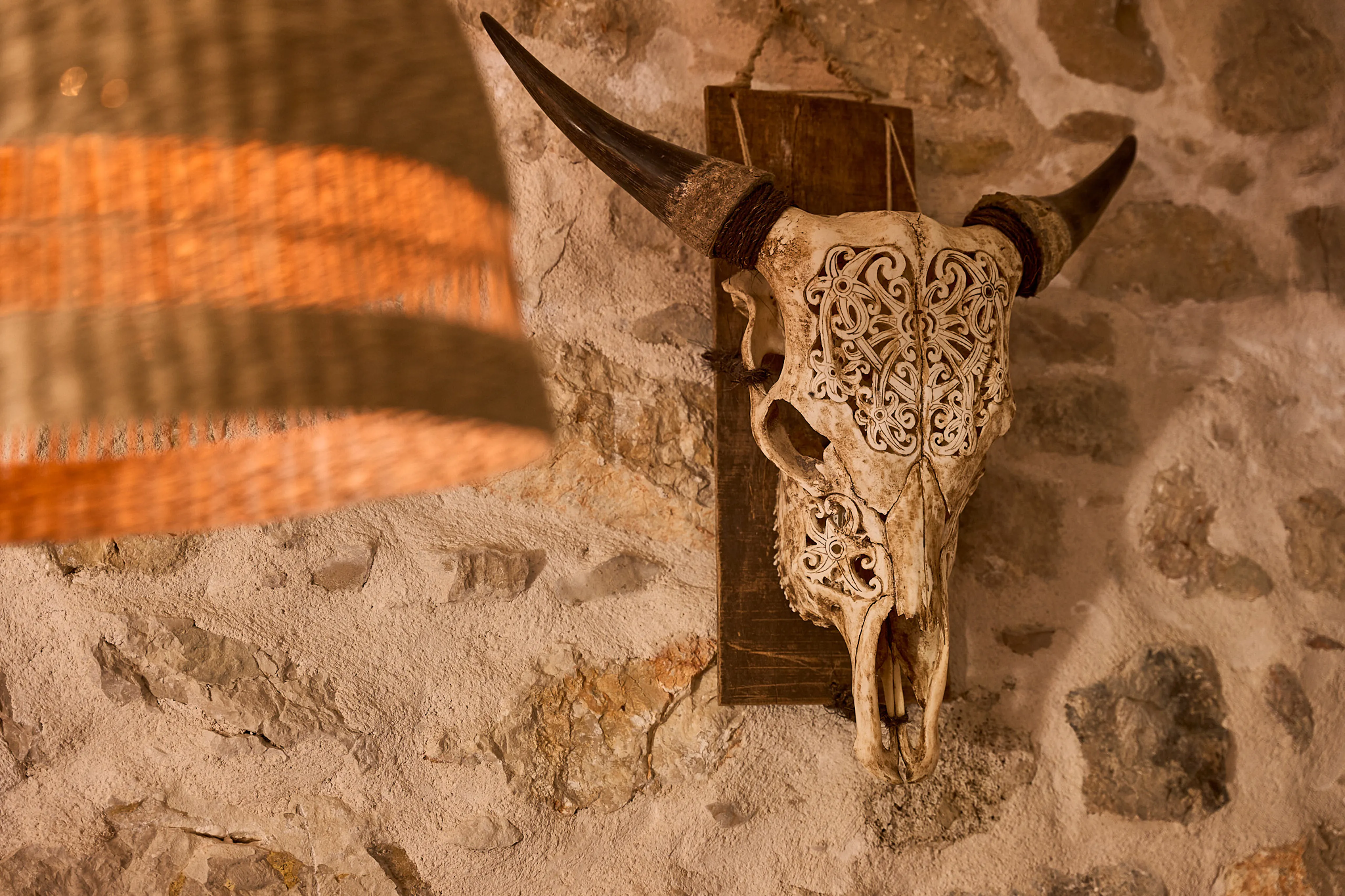 Decorative carved skull mounted on original stone wall in the Silvija Suite, Hidden House, Stari Grad