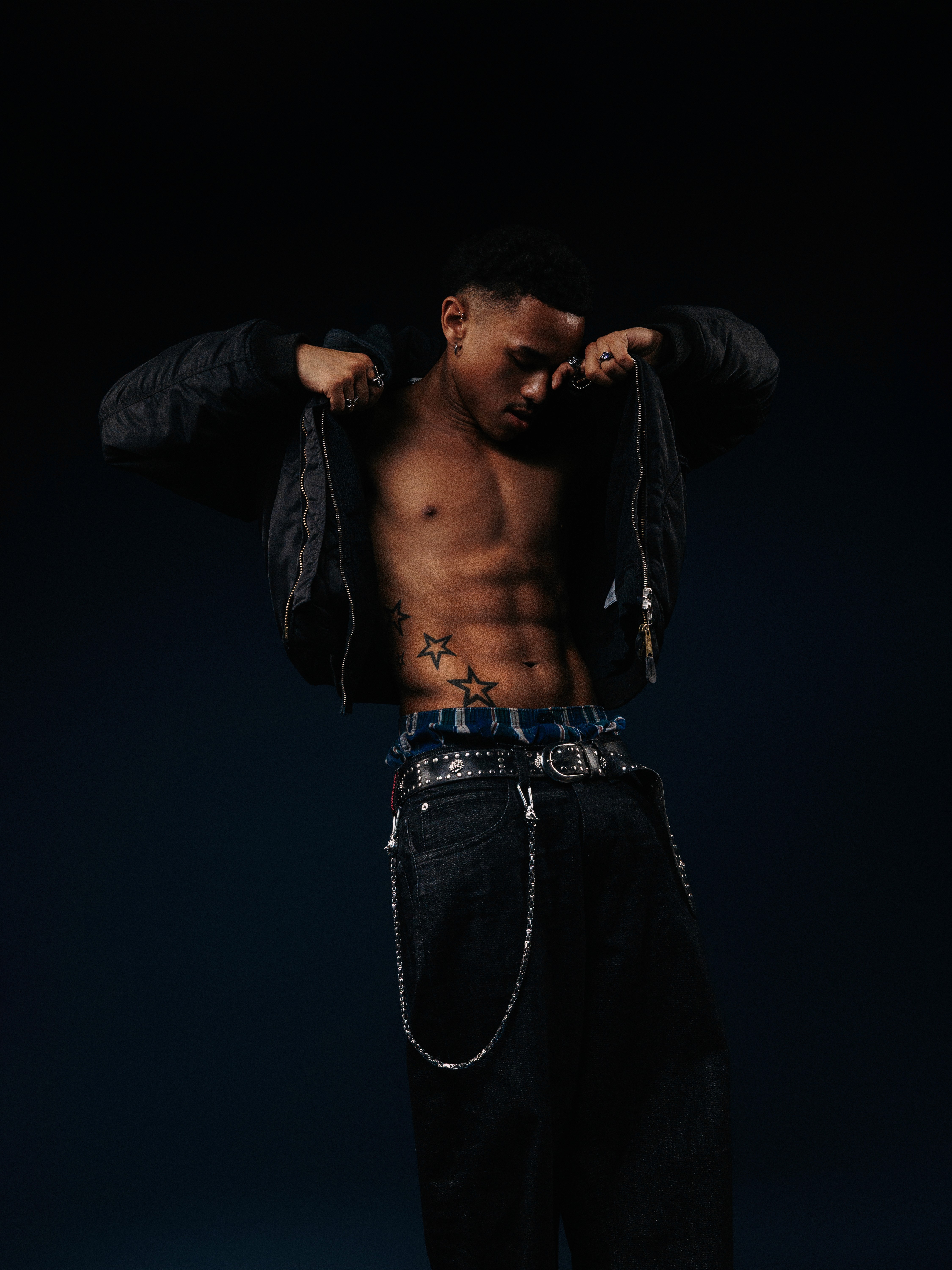 Boy posing in front of a dark background.