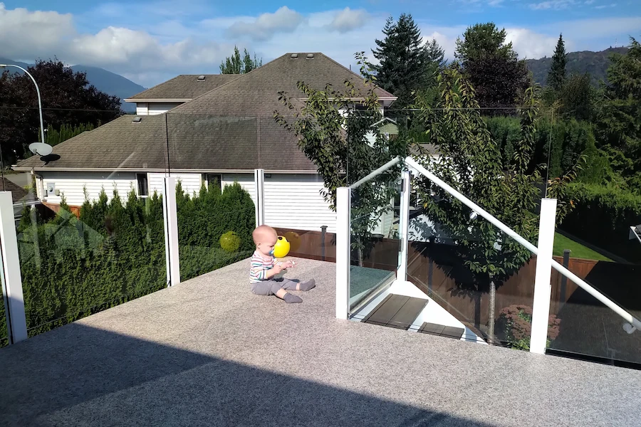 White post and glass deck railing semi-frameless system on residential terrace in Victoria BC.