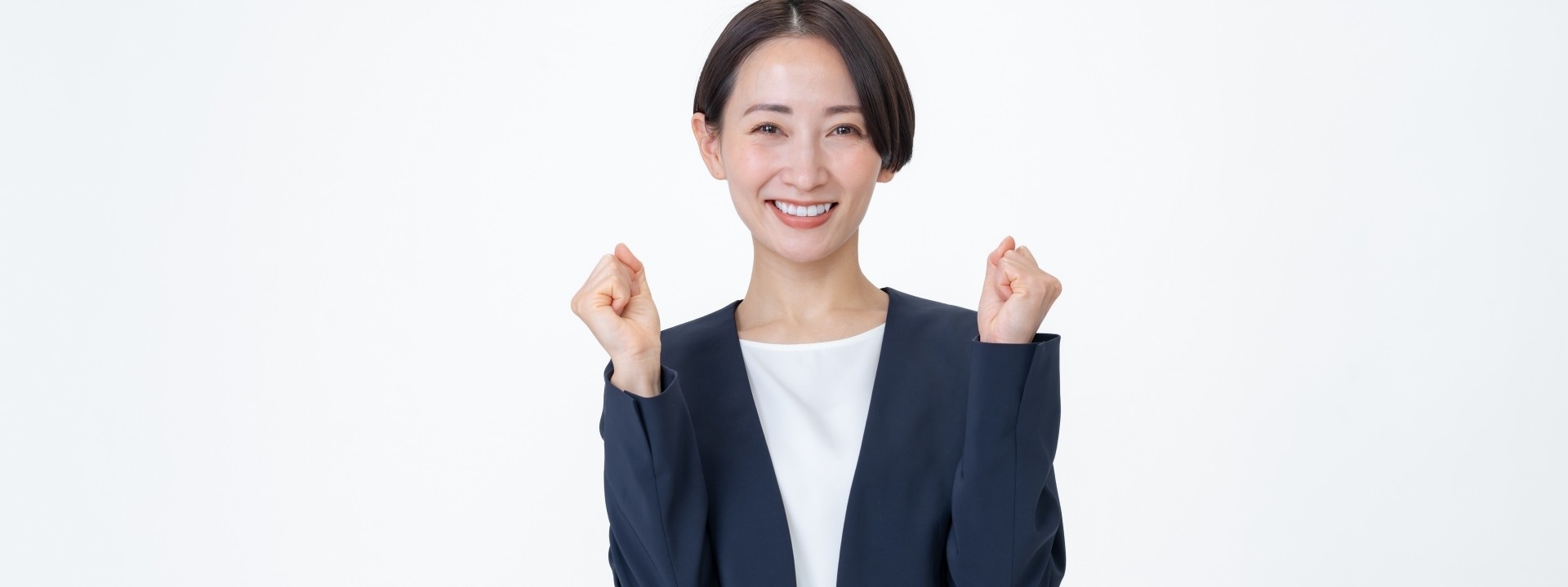 ビジネススーツの女性がガッツポーズをしている画像