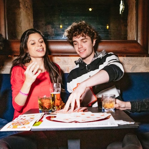A woman and two guys playing cards