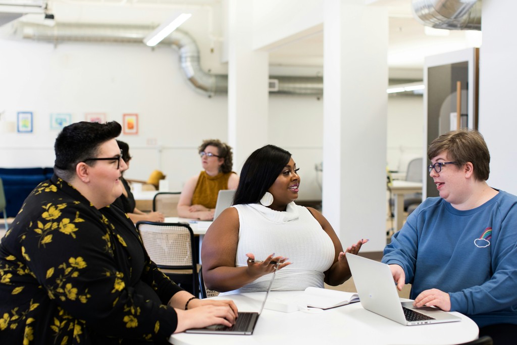 Three people sitting around a table having a discussion