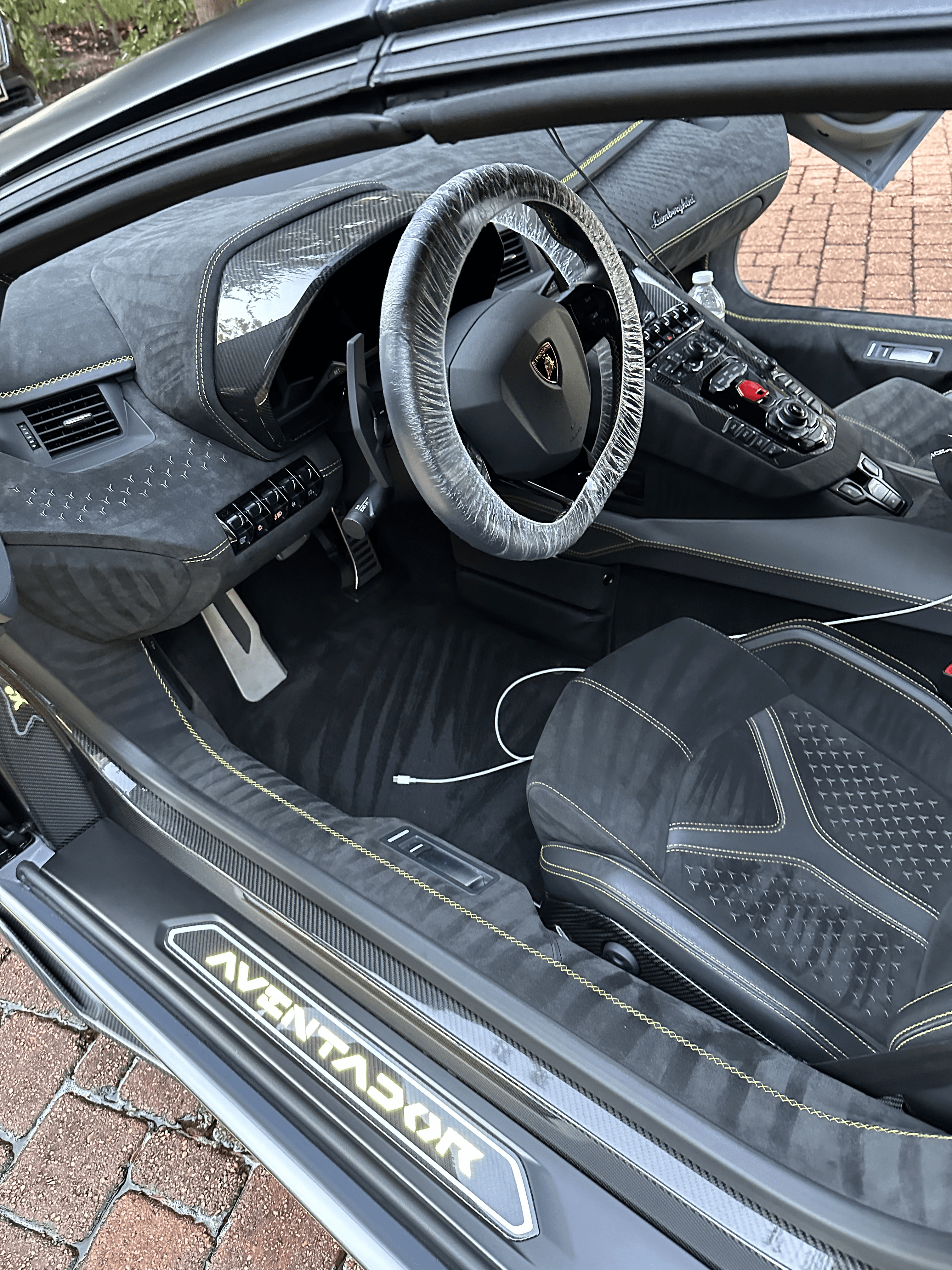 Detailed interior of a Lamborghini featuring a deep-cleaned steering wheel, center console, and upholstery as part of a premium full interior and exterior detailing package in Houston.