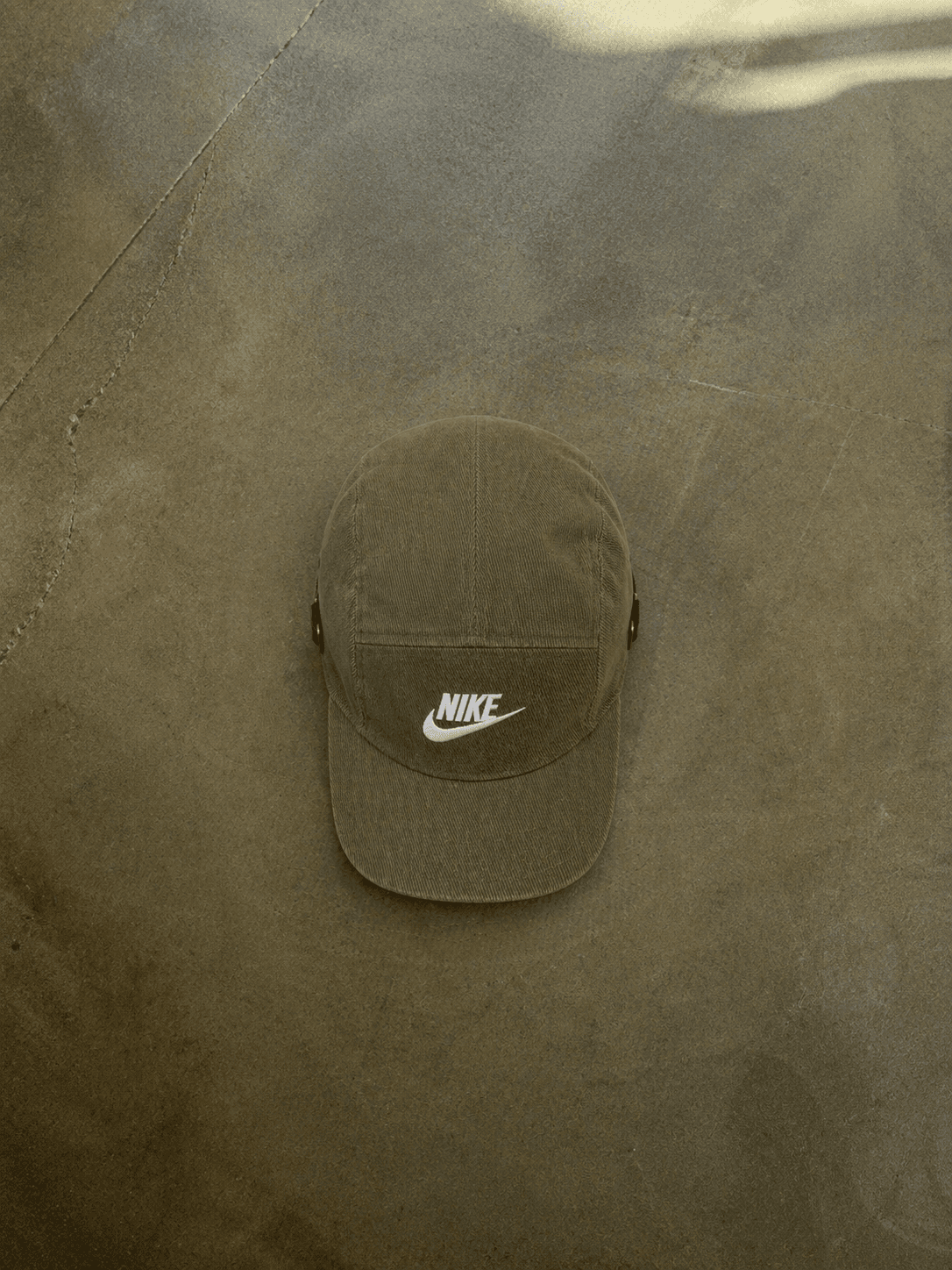 Green Nike cap on a textured brown surface