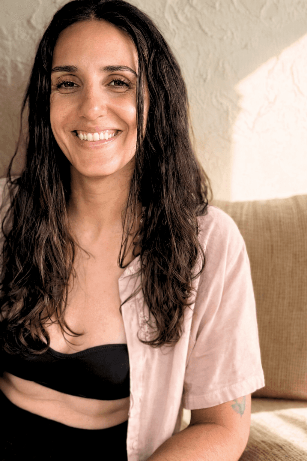 A woman is smiling at the camera, looking peaceful and relaxed