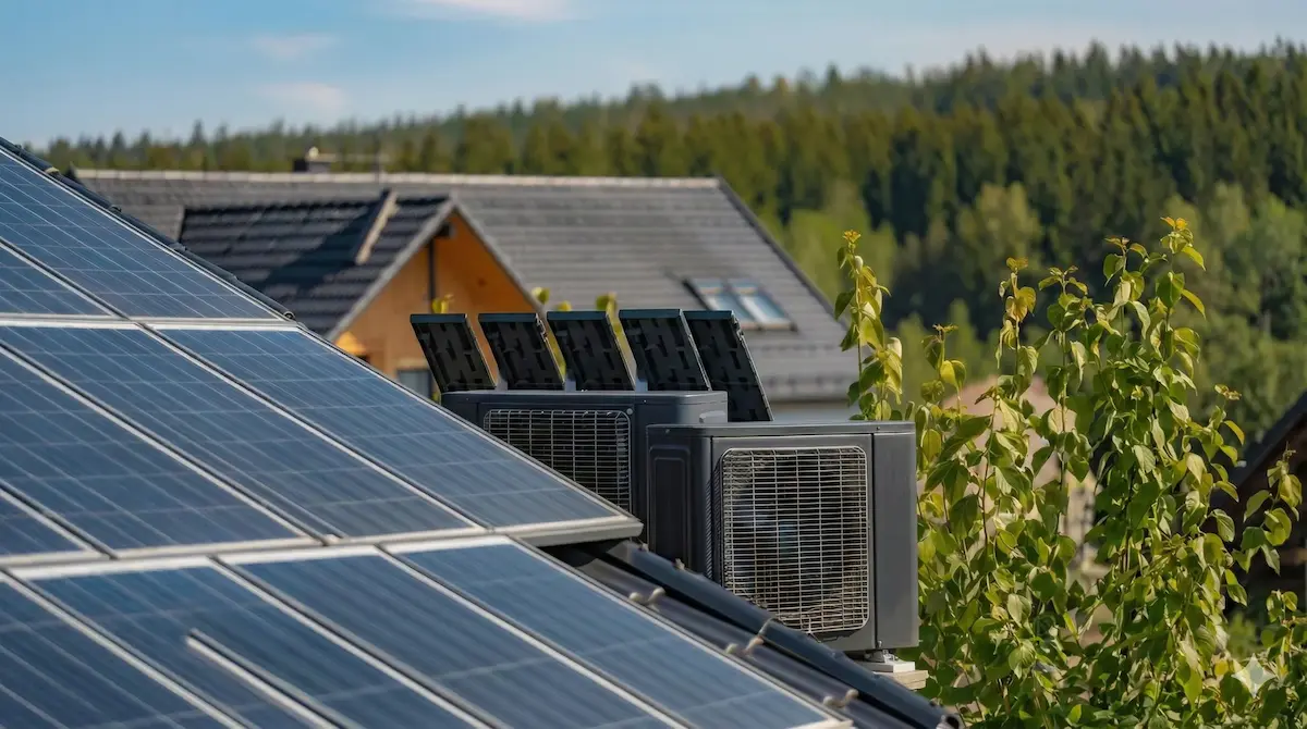 Vue d’une pompe à chaleur et de panneaux photovoltaïques sur la toiture d’une maison individuelle